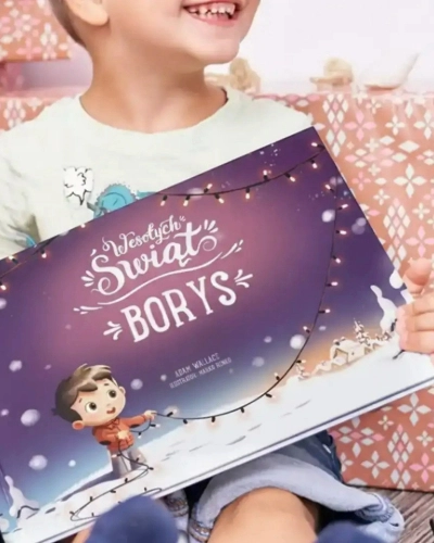 Dziecko trzyma spersonalizowaną książkę świąteczną z napisem ‘Wesołych Świąt Borys’ w zimowej scenerii.
